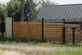 Part of a brown wall of a fence made of wooden planks