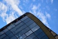 Part of building from glass and metal on background of blue sky with clouds. Construction of modern skyscrapers Royalty Free Stock Photo