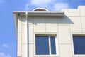 Part of a building wall with window and gutter against the blue sky Royalty Free Stock Photo