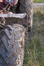 Part of the cab and wheels of a dirty tractor. Sunny day. Selective focus. Close up.