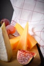 Part of Cheeseboard platter with hard and soft mould cheese, grape and segmented fig on wooden board