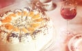 Part of a coffee table with tangerine-cream-cake, rosewine glass