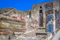 Part of the colored brick wall and street in Pompeii, Naples, Italy. The ruins of the ancient city, excavations of Pompei scavi. Royalty Free Stock Photo