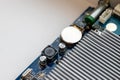 Part of a computer motherboard with capacitors, a battery and a cooling radiator Royalty Free Stock Photo