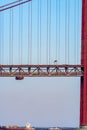 Part of the 25 de Abril suspension bridge with red steel cables where road traffic circulates to access Lisbon, and a double-lane Royalty Free Stock Photo