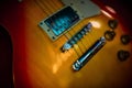 Part of an electric guitar. Yellow electric guitar deck. Shallow depth of field, atmospheric concert light.