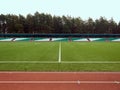 Part of an empty stadium, a running track, a football field and bleachers Royalty Free Stock Photo