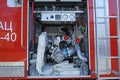 Part of equipment of a firetruck compartment: water pump, control panel, manometers and hose joined