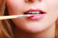 Part of face. Woman applying pink lipstick with brush Royalty Free Stock Photo