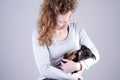 Part of a female, she lovingly holds a tiny sleeping Jack Russel Terrier puppy in her arms Royalty Free Stock Photo