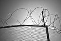 Part of the fence is made of metal mesh and barbed wire. The concept of restriction of freedom of movement. Black and white