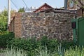 Part of a fence wall made of brown gray stones and brick Royalty Free Stock Photo