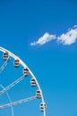 Part of ferris wheel against a blue sky background. Ferris wheel with cabins in a minimalist style. Straight view of ferris wheel