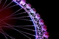 Part of ferris wheel with purple lighting at night