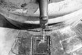 Part of the fountain in the form of a protruding relief metal faucet from a semicircular marble bowl with a trickle of water Royalty Free Stock Photo