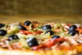 Part of freshly prepared Italian homemade pizza: olives, ham, pepper, sauce, cucumber, cheese. Close-up.