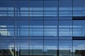 Part of geometric glass facade from modern office building with reflections. Royalty Free Stock Photo