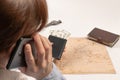 Part of a girl talking on the phone holds in her hand a black wallet with money on the background of a white wooden table with a d Royalty Free Stock Photo