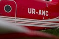 Part of the gleaming hull of a red UR ANC small passenger plane in sunset light. Exhibit of the National Museum of