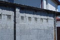 part of the gray brick attic of the building with a row of small square windows Royalty Free Stock Photo