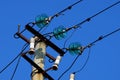 Part of a concrete pillar with wires against a blue sky