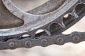 part of a gray metal sprocket with a black iron chain Royalty Free Stock Photo