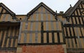 Part of a half timber framed building with ornate carvings on some of the facia boards