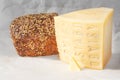 Part of a head of asiago cheese and a small piece of butter on a blurred background