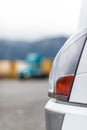 Part of the headlights and bumper of modern big rig semi truck parked near the warehouse Royalty Free Stock Photo