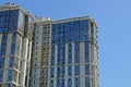 Part of a high gray house with windows and balconies against the blue sky Royalty Free Stock Photo