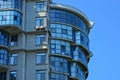 Part of a high gray house with windows and balconies against the blue sky Royalty Free Stock Photo