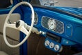 Part of the interior of blue old timer car with steering wheel, speedometer, oil, temperature dials, front panel Royalty Free Stock Photo