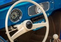 Part of the interior of blue old timer car with steering wheel, speedometer, oil, temperature dials, front panel Royalty Free Stock Photo