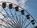 Part of large Ferris wheel against the background of summer daytime blue sky with clouds. Empty booths, no people. Attraction. Royalty Free Stock Photo