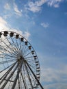 Part of large Ferris wheel against the background of summer daytime blue sky with clouds. Empty booths, no people. Attraction. Royalty Free Stock Photo