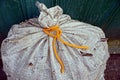Part of a large old gray bag tied with an orange lace Royalty Free Stock Photo