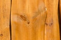 Part of light uncolored rough wooden fence with bent planks.