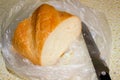 Part of a loaf in a cellophane bag with a knife next to it