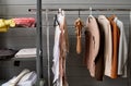 Part of long rack with variety of casual clothes of different colors in workshop