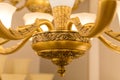 A part of lower part of the gold-colored armature of ceiling chandelier in the switched-on state with white matte plafonds Royalty Free Stock Photo