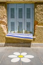 Part of modern building. Window with closed shutters. Architecture. Exterior, fragment. Flower painted on tiled floor outdoor.