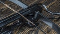 Part of modern compound crossbow handgun on the dark wooden background. Old weapon concept.