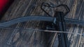 Part of modern compound crossbow handgun on the dark wooden background. Old weapon concept.