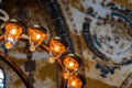 Part of a modern electric chandelier with warm light in front of a blurred painted ceiling in a historic building. Royalty Free Stock Photo