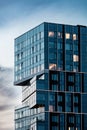 part of a modern glass building against a blue sky with clouds. contemporary cubism design exterior Royalty Free Stock Photo