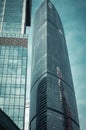 Part of modern glass skyscraper in the morning light. Perspective view of commercial building on th background of clear blue sky