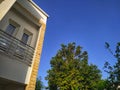 Part of modern house & window balcony, blue sky & a tree Royalty Free Stock Photo