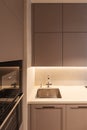 A part of modern kitchen interior with sink, oven and grey cupboard Royalty Free Stock Photo