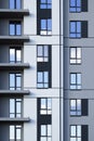 A part of modern residential building facade with reflection of cloudy blue sky in windows Royalty Free Stock Photo