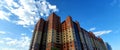 Part of a modern residential complex, an apartment building against a blue sky with clouds. Royalty Free Stock Photo